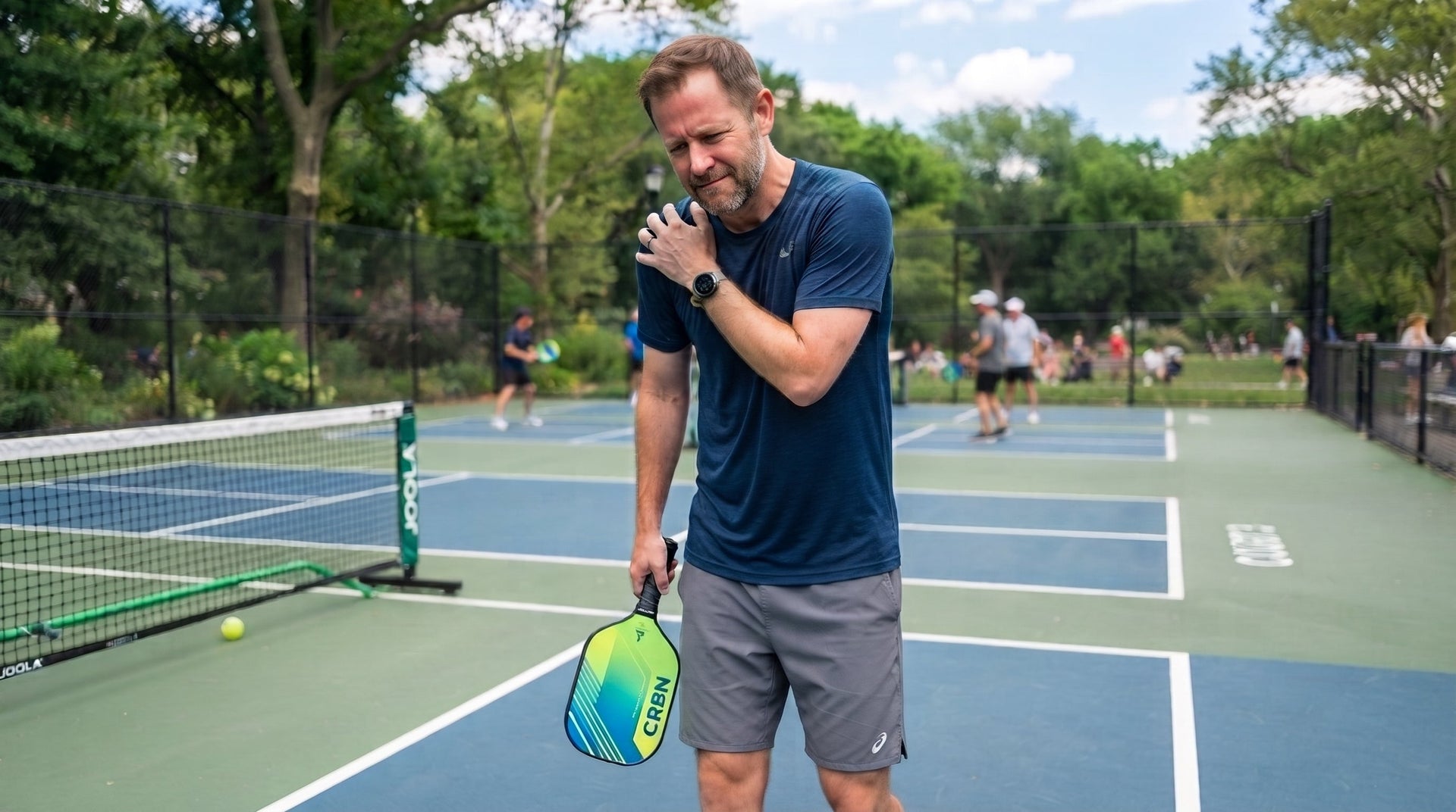 A man holding his shoulder experiencing a pickleball shoulder injury
