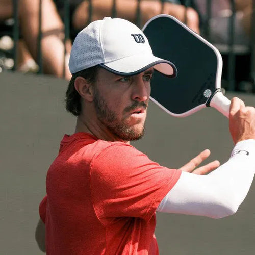 Man playing pickleball holding a paddle on a court
