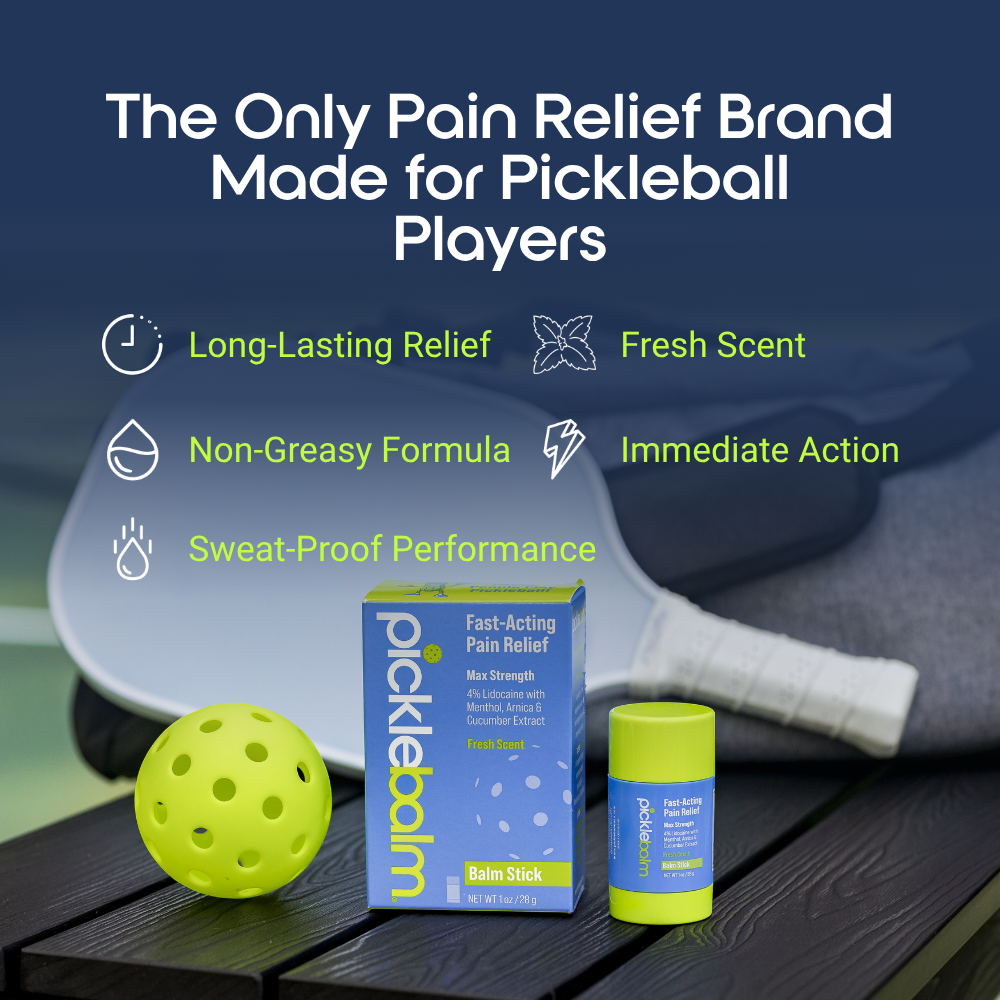 Picklebalm Pain Relief Balm Stick with pickleball ball and paddle on a dark surface